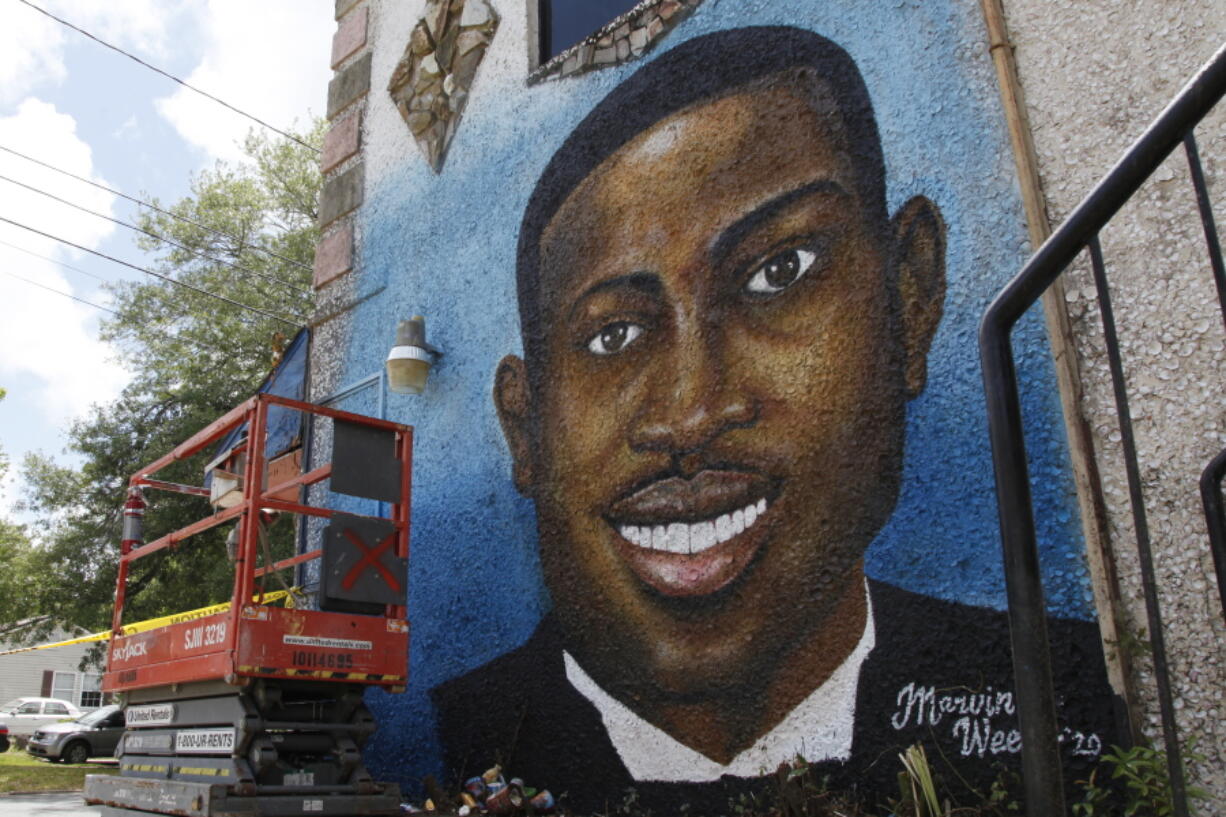 FILE - This May 17, 2020, file photo, shows a mural depicting Ahmaud Arbery in Brunswick, Ga.  Travis McMichael, the man convicted of murder for shooting Ahmaud Arbery is withdrawing his guilty plea on a federal hate crime charge.  McMichael announced his decision Friday, Feb. 4, 2022.