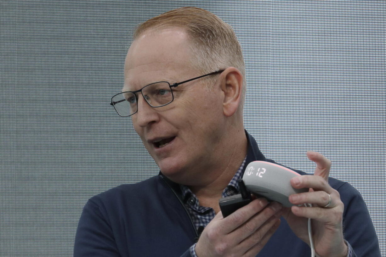 FILE - Dave Limp, senior vice president for Amazon devices & services, holds an Echo Dot with Clock device as he speaks Sept. 25, 2019, in Seattle. Amazon and telemedicine provider Teladoc Health are starting a voice-activated virtual care program that lets customers get medical help without picking up their phones. The service, for health issues that aren't emergencies, will be available on Amazon's Echo devices. Customers can tell the voice assistant Alexa that they want to talk to a doctor, and that will prompt a call back on the device from a Teladoc physician. The program, announced Monday, Feb. 28, 2022 marks Amazon's latest health care expansion and another push into telemedicine. (AP Photo/Ted S.