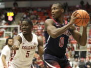 Washington State guard TJ Bamba (5) puts pressure on Arizona guard Bennedict Mathurin (0) during the first half of an NCAA college basketball game, Thursday, Feb. 10, 2022, in Pullman, Wash.