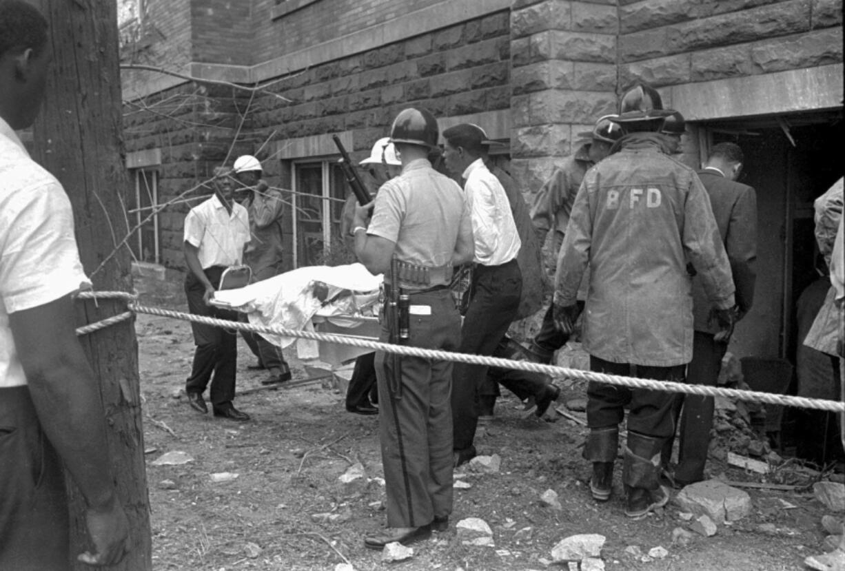 FILE - Firefighters and ambulance attendants remove a covered body from the 16th Street Baptist Church in Birmingham, Ala., after a deadly explosion detonated by members of the Ku Klux Klan during services on Sept. 15, 1963. Threats against Black institutions are deeply rooted in U.S. history and leaders say the history of violence against people of color should be passed on to new generations so the lessons of the past can be applied to the present.