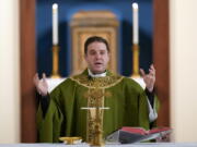 Father Matthew Hood celebrates Mass at Our Lady of the Rosary church Friday in Detroit. Hood was one of many whose baptism was invalid because of incorrect wording.