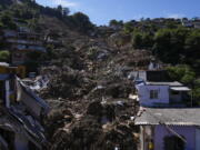 The path of a mudslide marks a hillside filled with homes in Petropolis, Brazil, Thursday, Feb. 17, 2022. Deadly floods and mudslides swept away homes and cars, but even as families prepared to bury their dead, it was unclear how many bodies remained trapped in the mud.