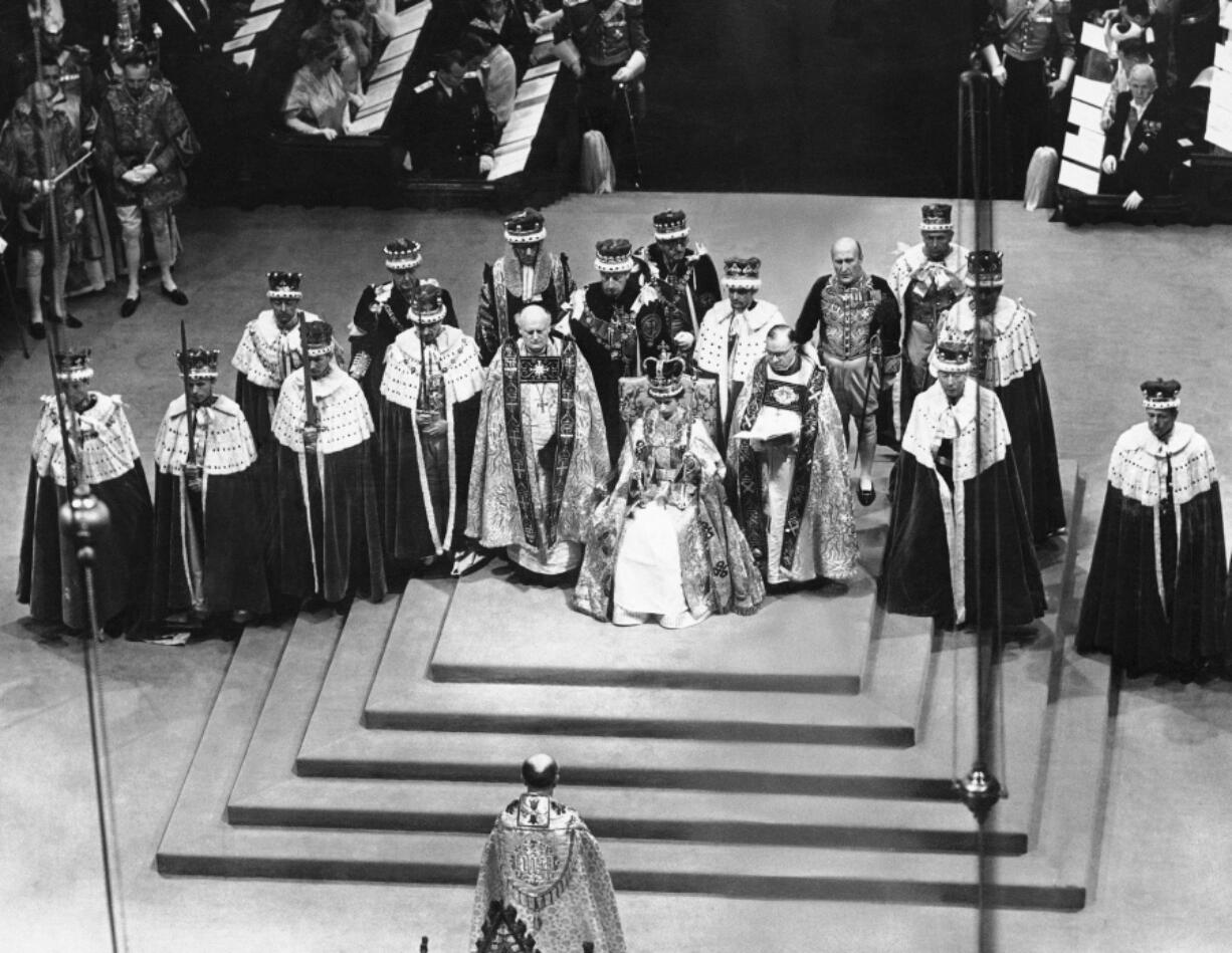 FILE - Surrounded by peers and churchmen, Queen Elizabeth II sits on throne in Westminister Abbey, London, June 2, 1953 after her coronation. Britain is marking Queen Elizabeth II's Platinum Jubilee on Sunday, Feb. 6, 2022, 70 years after she ascended to the throne.