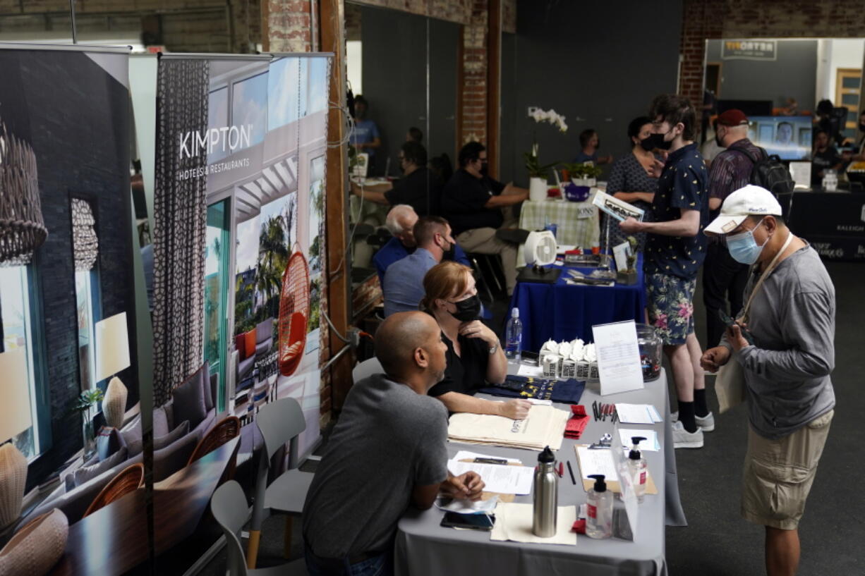 FILE - Prospective employers and job seekers interact during during a job fair on Sept. 22, 2021, in the West Hollywood section of Los Angeles. California's unemployment rate dipped a half-percentage point in December as the most populous state added 50,700 nonfarm jobs, accounting for more than a quarter of the nation's 199,000 job growth for the month, according to new data released Friday, Jan. 21, 2022.