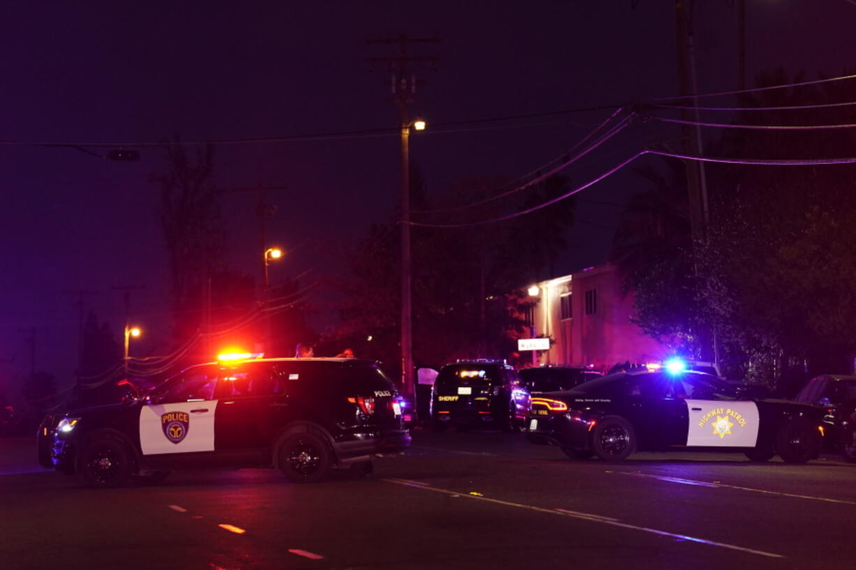 Law enforcement vehicles from several agencies block a street near the scene of a shooting in Sacramento, Calif., Monday, Feb. 28, 2022.