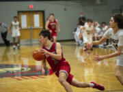 Castle Rock’s Trevor Rogen dribbles away from Giovanny Evanson after making a late seal to help seal the Rockets’ 46-43 win over King’s Way Christian in the 1A district semifinal (Tim Martinez/The Columbian)