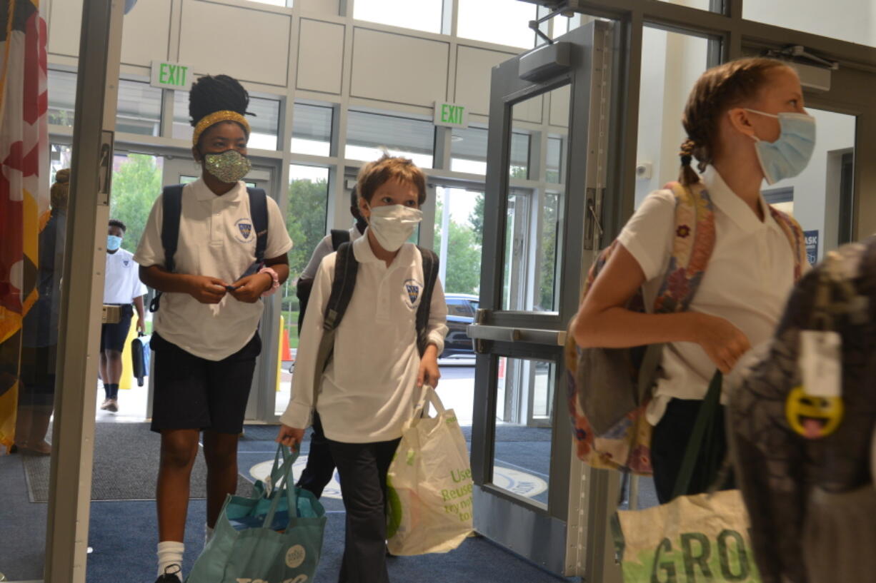 FILE - Students enter the first new Catholic school built in Baltimore in roughly 60 years on Monday, Aug. 30, 2021, named after Mother Mary Lange, who started a Catholic school for Black children in 1828 -- the first U.S. Catholic school for African-American youth. Enrollment in Roman Catholic schools in the United States rose 3.8% from the previous academic year, rebounding from a sharp drop caused by the coronavirus pandemic, Catholic education officials reported Monday, Feb. 14, 2022.