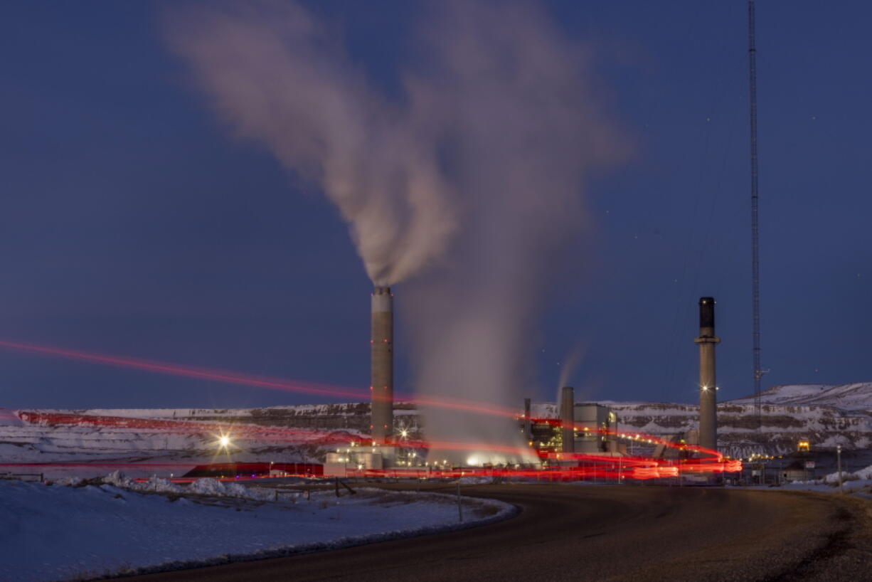 In this photo taken with a slow shutter speed, taillights trace the path of a motor vehicle at the Naughton Power Plant, Thursday, Jan. 13, 2022 in Kemmerer, Wyo. While the power plant will be closed in 2025, Bill Gates' company TerraPower announced it had chosen Kemmerer for a nontraditional, sodium-cooled nuclear reactor that will bring on workers from a local coal-fired power plant scheduled to close soon.