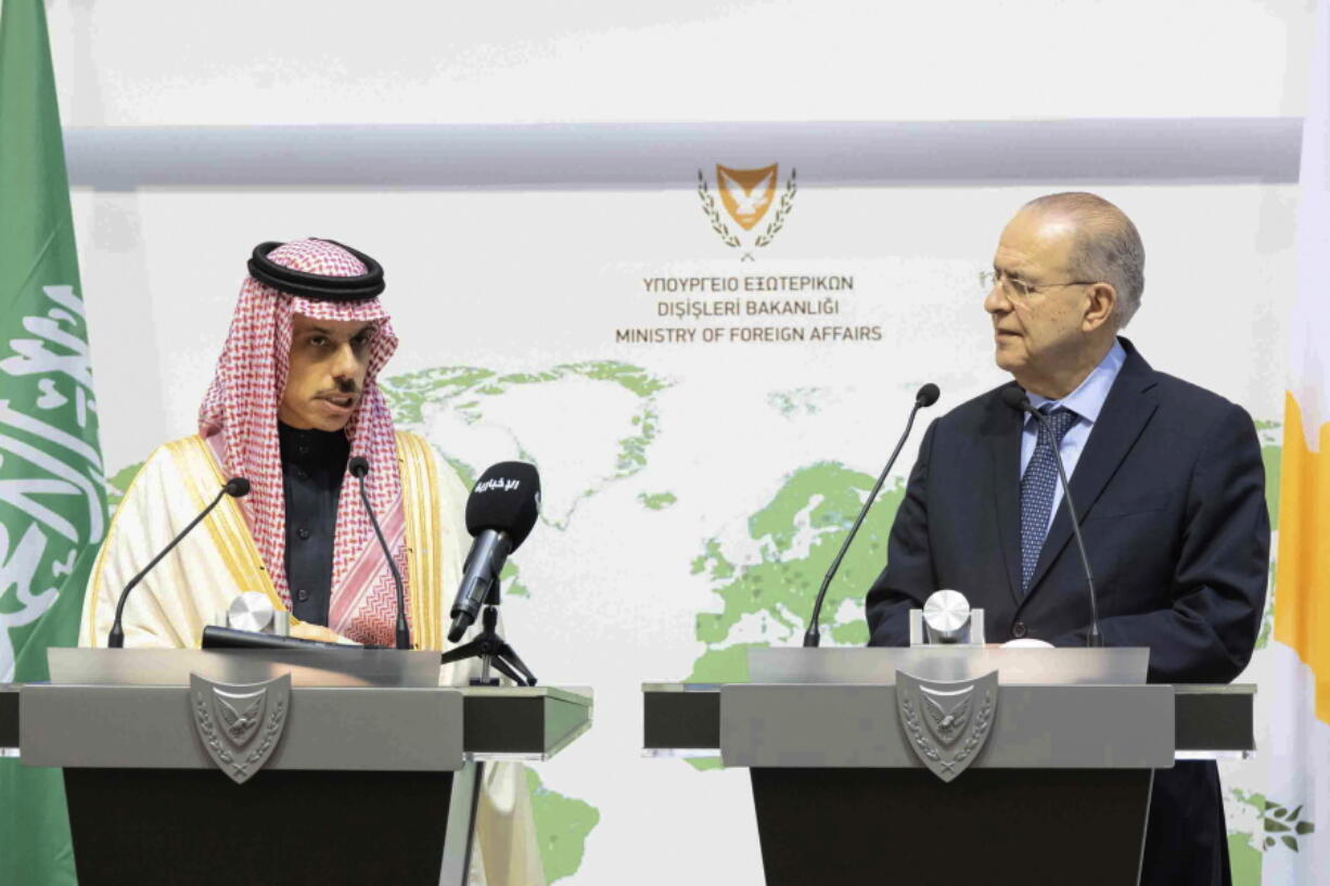 This image provided by Cyprus Press and Informations Office, shows Saudi Foreign Minister Prince Faisal Bin Farhan Al-Saud, left and Cyprus Foreign Minister Ioannis Kasoulides speaking to the media, during a press conference after their meeting, at the foreign ministry house in capital Nicosia, Cyprus, Sunday, Feb. 13, 2022. The Saudi foreign minister says his country views Cyprus as a "bridge" between the Middle East and the European Union, helping the 27-nation bloc "understand what's going on" in the region.