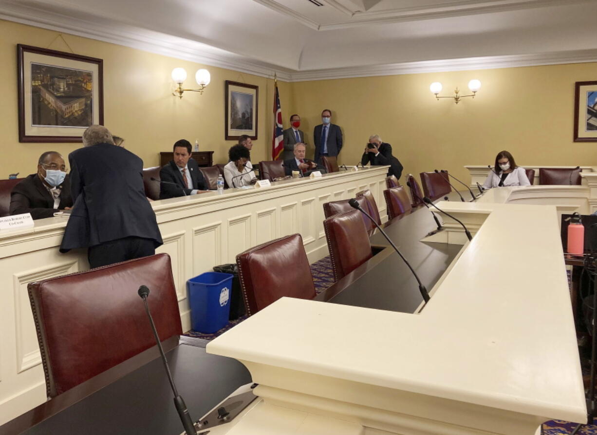 FILE - In this Sept. 15, 2021, photo, Republican Ohio Gov. Mike DeWine, foreground, speaks to state Sen. Vernon Sykes, seated, the co-chair of the Ohio Redistricting Commission, as other members of the panel prepare for a meeting on at the Ohio Statehouse in Columbus, Ohio. The GOP's focus on the makeup of state supreme courts escalated this week after a series of legal setbacks frustrated the party's effort to redraw congressional maps in Pennsylvania and North Carolina. That prompted some leading Republicans to press the party to pay more attention to elections in November in which some supreme court justices will face voters.