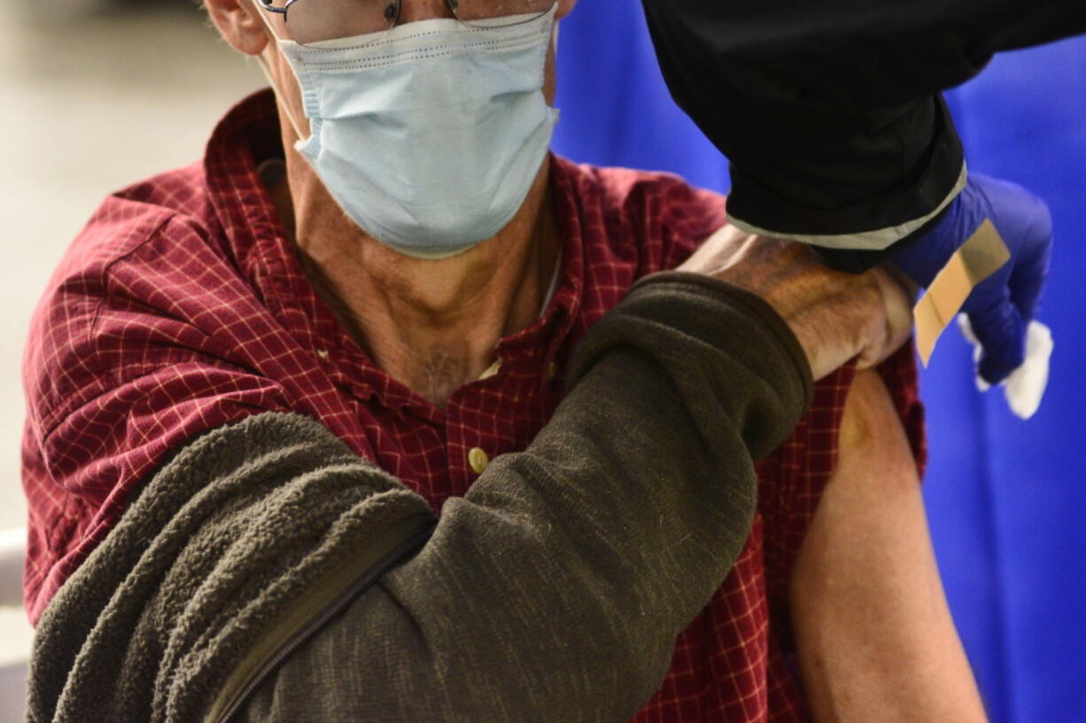 FILE - A man receives a flu shot in Brattleboro, Vt., on Tuesday, Oct. 26, 2021. This winter's mild flu season has faded to a trickle of cases in much of the U.S., according to data released by the Centers for Disease Control and Prevention in February 2022, but health officials are not ready to call it over.