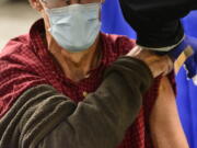 FILE - A man receives a flu shot in Brattleboro, Vt., on Tuesday, Oct. 26, 2021. This winter's mild flu season has faded to a trickle of cases in much of the U.S., according to data released by the Centers for Disease Control and Prevention in February 2022, but health officials are not ready to call it over.