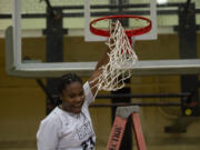 Senior Aniyah Hampton celebrates after cutting down the net after Hudson's Bay beat Woodland 60-18 to clinch the 2A Greater St. Helens League girls basketball title on Thursday, Feb. 3, 2022.