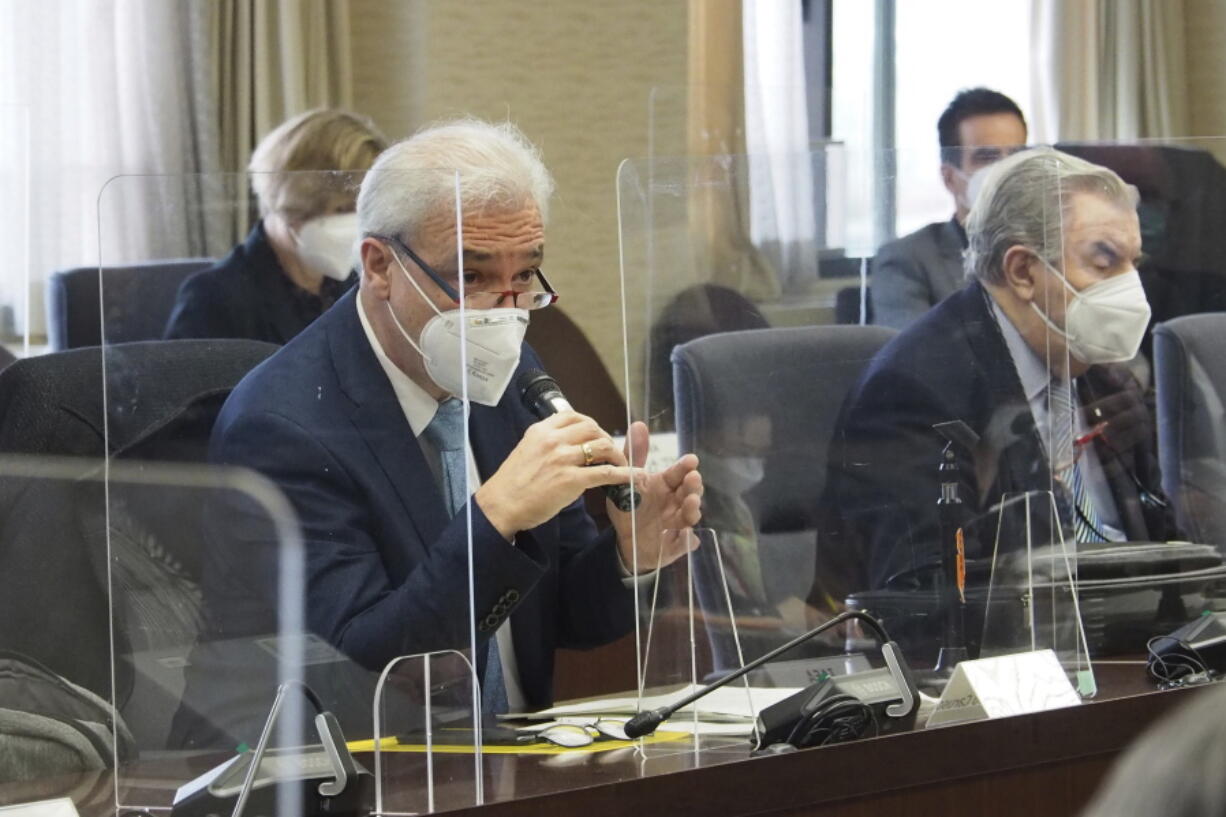 In this photo provided by Japan's Ministry of Economy, Trade and Industry (METI), Gustavo Caruso, left, director and safety coordination of the IAEA taskforce, speaks during a meeting with the government officials, at the ministry in Tokyo Monday, Feb. 14, 2022. The 15-member team on Monday began their review in Japan of a planned release to sea of treated radioactive water from the wrecked Fukushima nuclear plant, a mission Japan hopes to address safety concerns over the controversial plan.