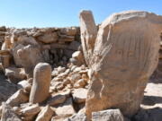 This photo provided by Jordan Tourism Ministry shows two carved standing stones at a remote Neolithic site in Jordan's eastern desert.  A team of Jordanian and French archaeologists said Tuesday, Feb. 22, 2022,  that it had found a roughly 9,000-year-old shrine.  The ritual complex was found in a Neolithic campsite near large structures known as "desert kites," or mass traps that are believed to have been used to corral wild gazelles for slaughter.