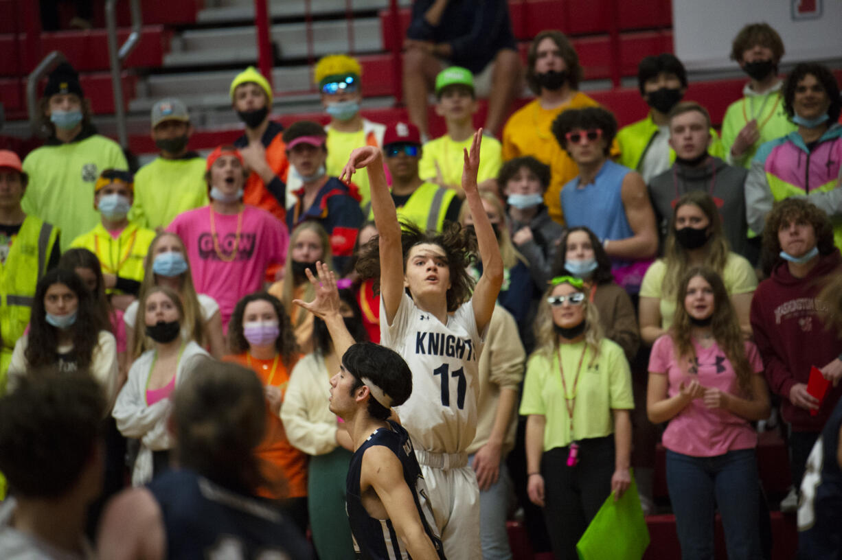 King’s Way Christian junior Giovanny Evanson (11) shoots a 3-pointer over Seton Catholic’s Jacob George as the Seton Catholic student section looks on during the Knights’ 53-43 win over Seton Catholic in a 1A district third-place game at Fort Vancouver High School on Friday.