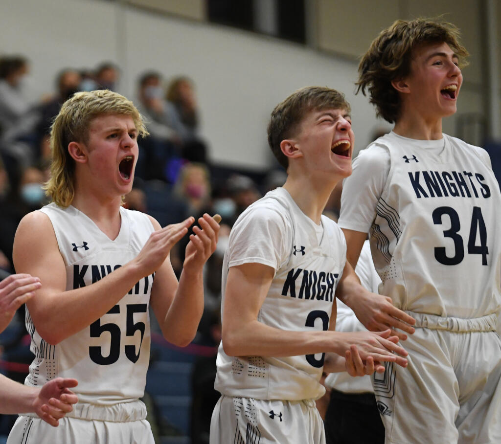 King’s Way sophomore Cade Erwin, left, senior Aidan Peterson, middle, and sophomore Brayden Schiefer celebrate after a basket Tuesday, Feb. 1, 2022, during the Knights’ 32-23 win against Seton Catholic at King’s Way Christian High School.