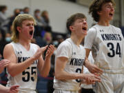 King’s Way sophomore Cade Erwin, left, senior Aidan Peterson, middle, and sophomore Brayden Schiefer celebrate after a basket Tuesday, Feb. 1, 2022, during the Knights’ 32-23 win against Seton Catholic at King’s Way Christian High School.