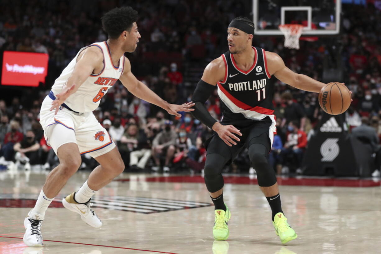 New York Knicks guard Quentin Grimes guards against Portland Trail Blazers forward Josh Hart during the first half of an NBA basketball game in Portland, Ore., Saturday, Feb. 12, 2022.