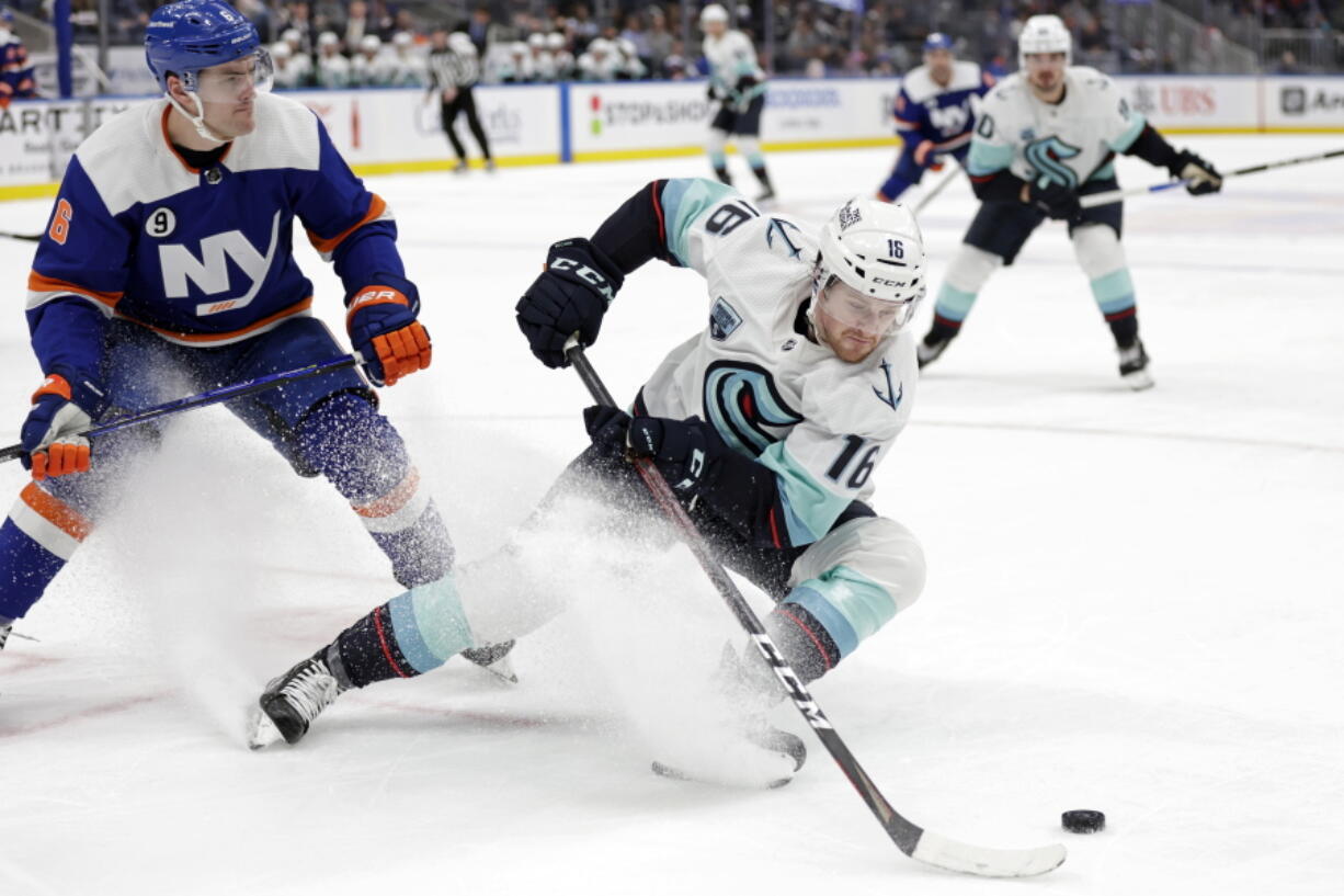 Seattle Kraken left wing Jared McCann (16) controls the puck in front of New York Islanders defenseman Ryan Pulock in the third period of an NHL hockey game Wednesday, Feb. 2, 2022, in Elmont, N.Y. The Kraken won 3-0.