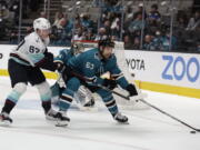 Seattle Kraken center Morgan Geekie (67) battles for the puck against San Jose Sharks left wing Jeffrey Viel (63) in the second period of an NHL hockey game in San Jose, Calif., Sunday, Feb. 27, 2022.