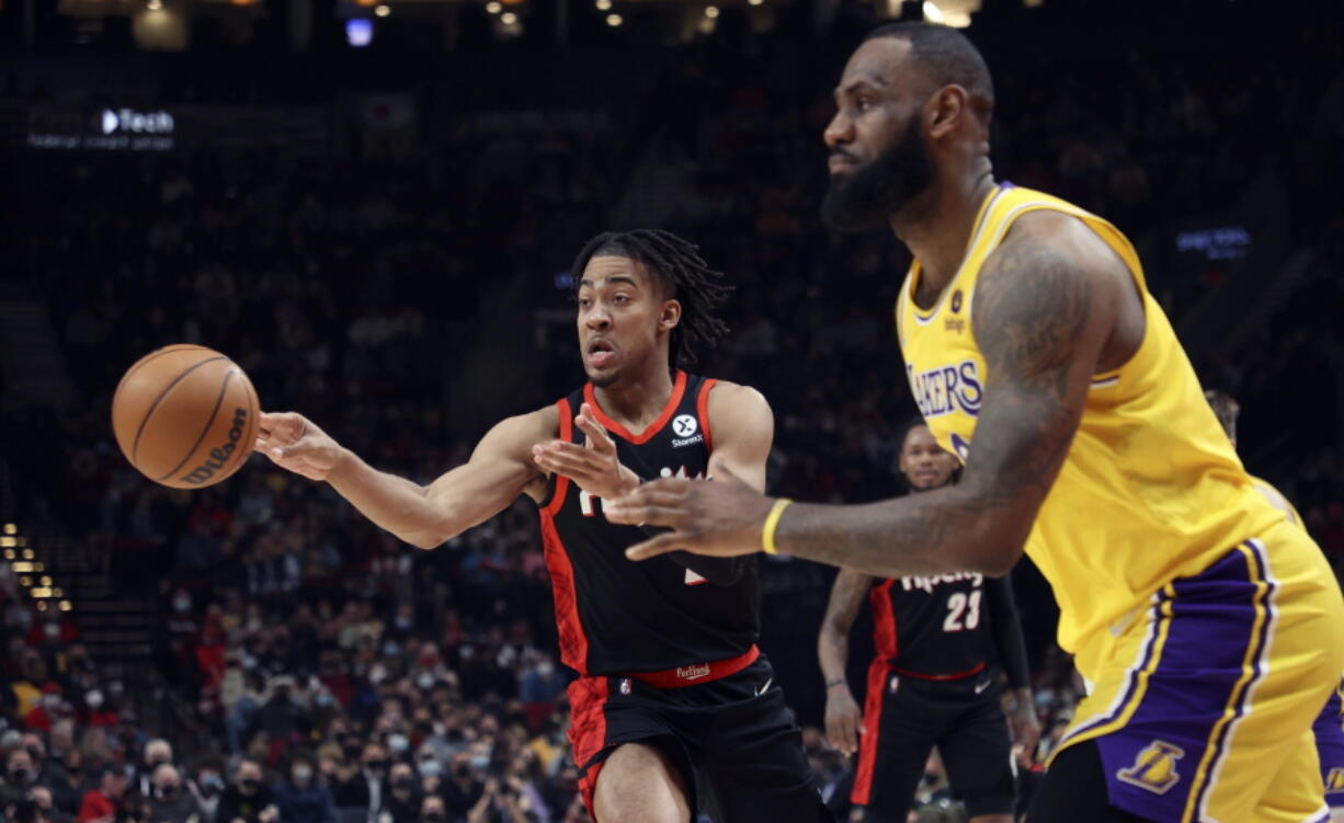 Portland Trail Blazers forward Trendon Watford, left, passes the ball as Los Angeles Lakers forward LeBron James, right, defends during the first half of an NBA basketball game in Portland, Ore., Wednesday, Feb. 9, 2022.