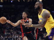 Portland Trail Blazers forward Trendon Watford, left, passes the ball as Los Angeles Lakers forward LeBron James, right, defends during the first half of an NBA basketball game in Portland, Ore., Wednesday, Feb. 9, 2022.