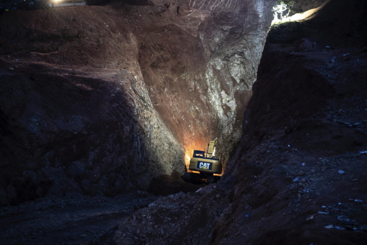 A tractor digs through a mountain during the rescue mission of a boy who fell into a hole in the northern village of Ighran in Morocco's Chefchaouen province, Friday, Feb. 4, 2022.