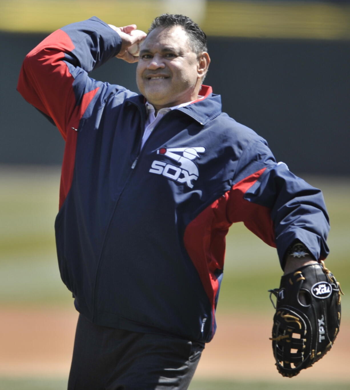 Former Chicago White Sox player Julio Cruz throws out the ceremonial first pitch before a baseball game between the Chicago White Sox and the Seattle Mariners in Chicago on Sunday April 7, 2013. Cruz, an original Seattle Mariners player from their inaugural season who later became a Spanish-language broadcaster for the franchise, has died, the team announced Wednesday, Feb. 23, 2022. Cruz played for Seattle and the Chicago White Sox during his career.