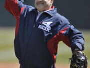 Former Chicago White Sox player Julio Cruz throws out the ceremonial first pitch before a baseball game between the Chicago White Sox and the Seattle Mariners in Chicago on Sunday April 7, 2013. Cruz, an original Seattle Mariners player from their inaugural season who later became a Spanish-language broadcaster for the franchise, has died, the team announced Wednesday, Feb. 23, 2022. Cruz played for Seattle and the Chicago White Sox during his career.