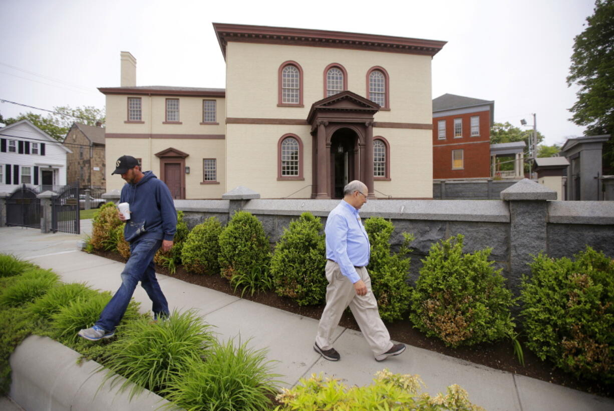 FILE - Employees Chuck Flippo, right, and Asa Montgomery walk through Patriots Park, Thursday, May 28, 2015, at the Touro Synagogue, the nation's oldest, in Newport, R.I. On Monday, Jan. 31, 2022, the New York-based Congregation Shearith Israel filed a court motion to take control of Touro Synagogue by ejecting its current tenants, the Newport-based Congregation Jeshuat Israel.