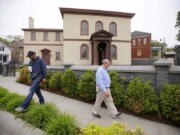 FILE - Employees Chuck Flippo, right, and Asa Montgomery walk through Patriots Park, Thursday, May 28, 2015, at the Touro Synagogue, the nation's oldest, in Newport, R.I. On Monday, Jan. 31, 2022, the New York-based Congregation Shearith Israel filed a court motion to take control of Touro Synagogue by ejecting its current tenants, the Newport-based Congregation Jeshuat Israel.