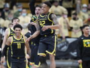 Oregon guard Jacob Young, front, celebrates with center Nate Bittle as time runs out in the second half of an NCAA college basketball game against Colorado, Thursday, Feb. 3, 2022, in Boulder, Colo.