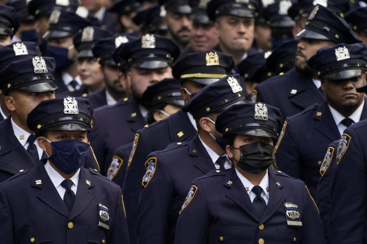 New York Police officers gather outside St. Patrick's Cathedral for Officer Wilbert Mora's funeral, Wednesday, Feb. 2, 2022, in New York. For the second time in under a week, police converged on New York City's St. Patrick's Cathedral to pay tribute to a young officer gunned down while answering a call for help in Harlem. Mora was shot along with Officer Jason Rivera on Jan. 22 while responding to a call about a domestic argument in an apartment.