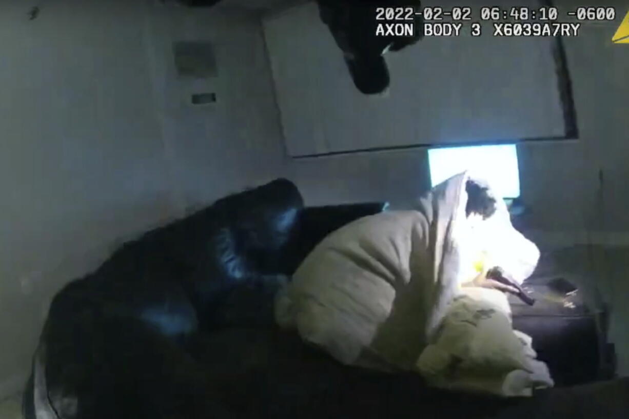 In this image taken from Minneapolis Police Department body camera video and released by the city of Minneapolis, 22-year-old Amir Locke wrapped in a blanket on a couch holding a gun moments before he was fatally shot by Minneapolis police as they were executing a search warrant in a homicide investigation on Wednesday, Feb. 2, 2022, in Minneapolis. Authorities have not said if Locke was connected to the homicide investigation or named in the warrant.