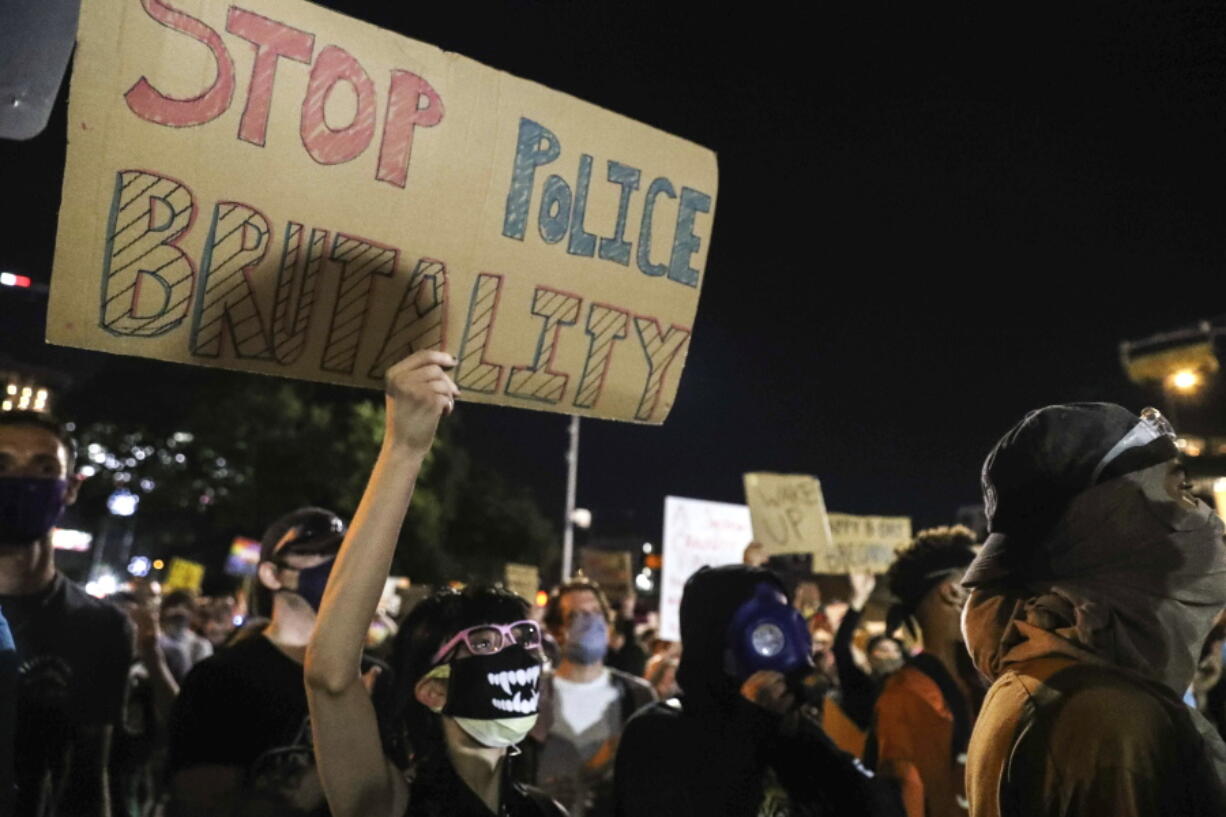 FILE - Protesters decry the death of George Floyd, Michael Ramos and police brutality against Black Americans in front of the Austin Police Department headquarters in Austin on June 5, 2020. The Austin City Council on Thursday, Feb. 17, 2022, approved paying a combined $10 million to two people injured when officers fired beanbag rounds into crowds during the 2020 social justice protests, including a college student who suffered brain damage.