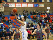 Ridgefield’s Sid Bryant drives to the hoop as Black Hills’ Keagan Rongen (30) looks on during the Spudders’ 54-40 win over Black Hills in the 2A boys basketball district tournament.