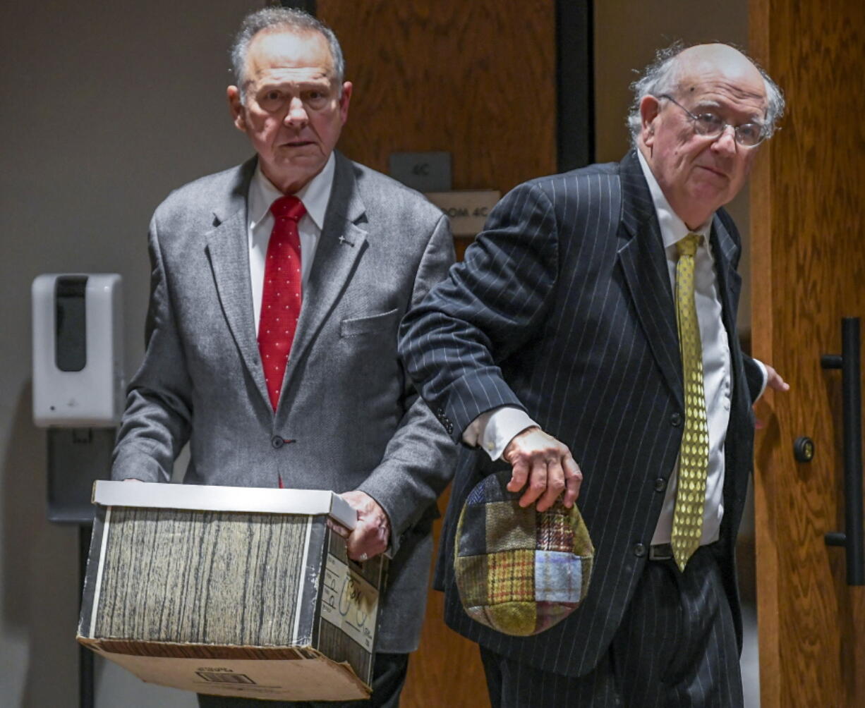 Former Alabama Chief Justice Roy Moore, left, and his attorney Julian McPhillips leave the courtroom in the Montgomery County Courthouse in Montgomery, Ala., on Monday, Jan. 24, 2022, following jury selection, as the trial with Leigh Corfman, who accused former Moore of sexual assault, and Moore's defamation lawsuits against each other begins.