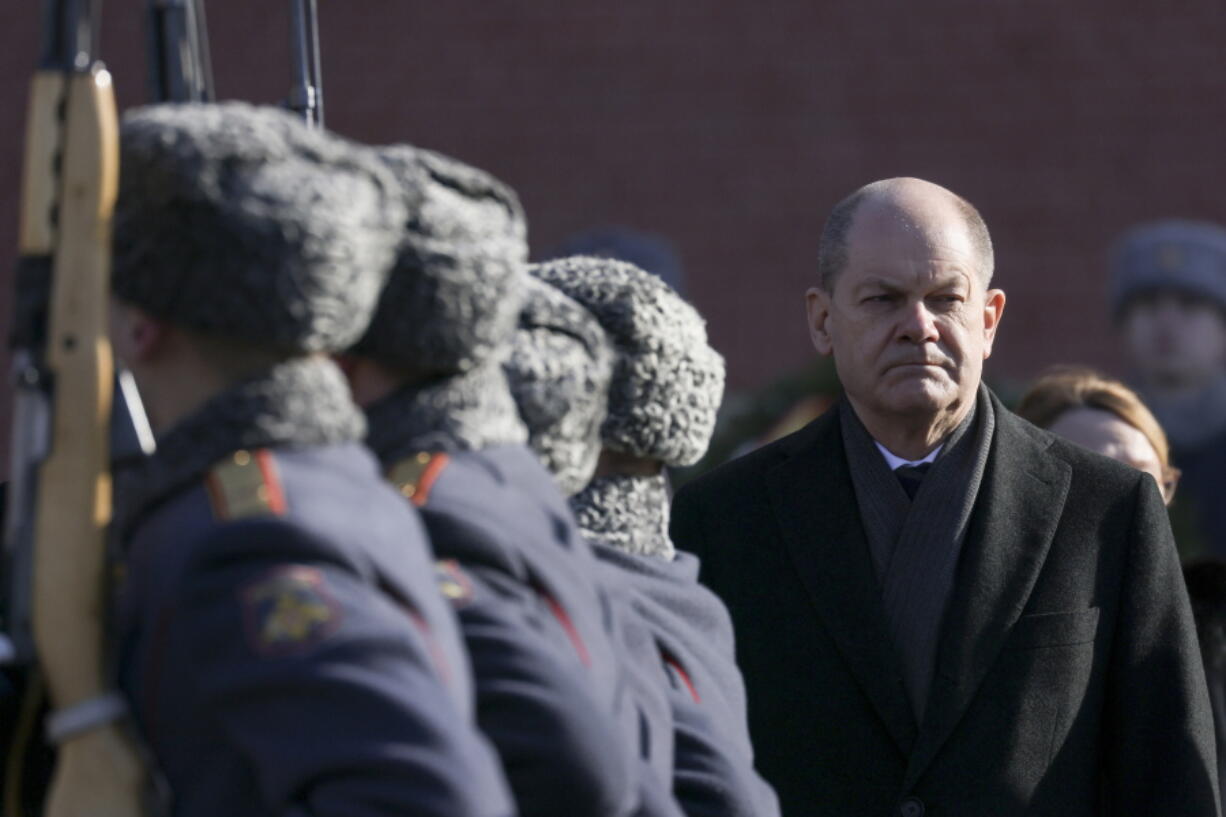 German Chancellor Olaf Scholz, right, attends a wreath-laying ceremony at the Tomb of the Unknown Soldier at the Kremlin Wall in Moscow, Russia, Tuesday, Feb. 15, 2022.