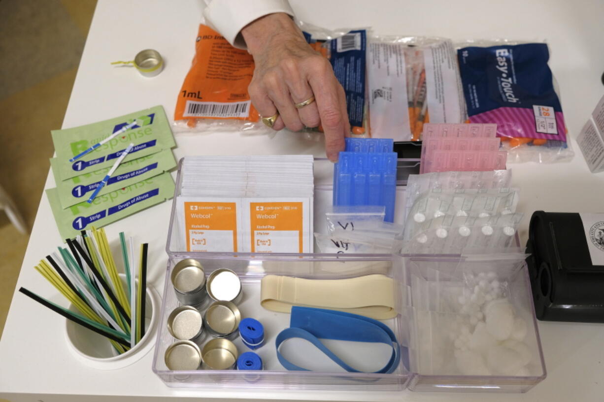 File - Supplies are shown on a desk at Safer Inside, a realistic model of a safe injection site in San Francisco,  Aug. 29, 2018. The Justice Department is signaling it might be open to allowing so-called safe injection sites, or safe havens for people to use heroin and other narcotics with protections against fatal overdoses. The department's stance comes a year after federal prosecutors won a major court ruling that found the sites would violate federal law. The Justice Department tells The Associated Press it is talking to regulators about "appropriate guardrails" for the sites.