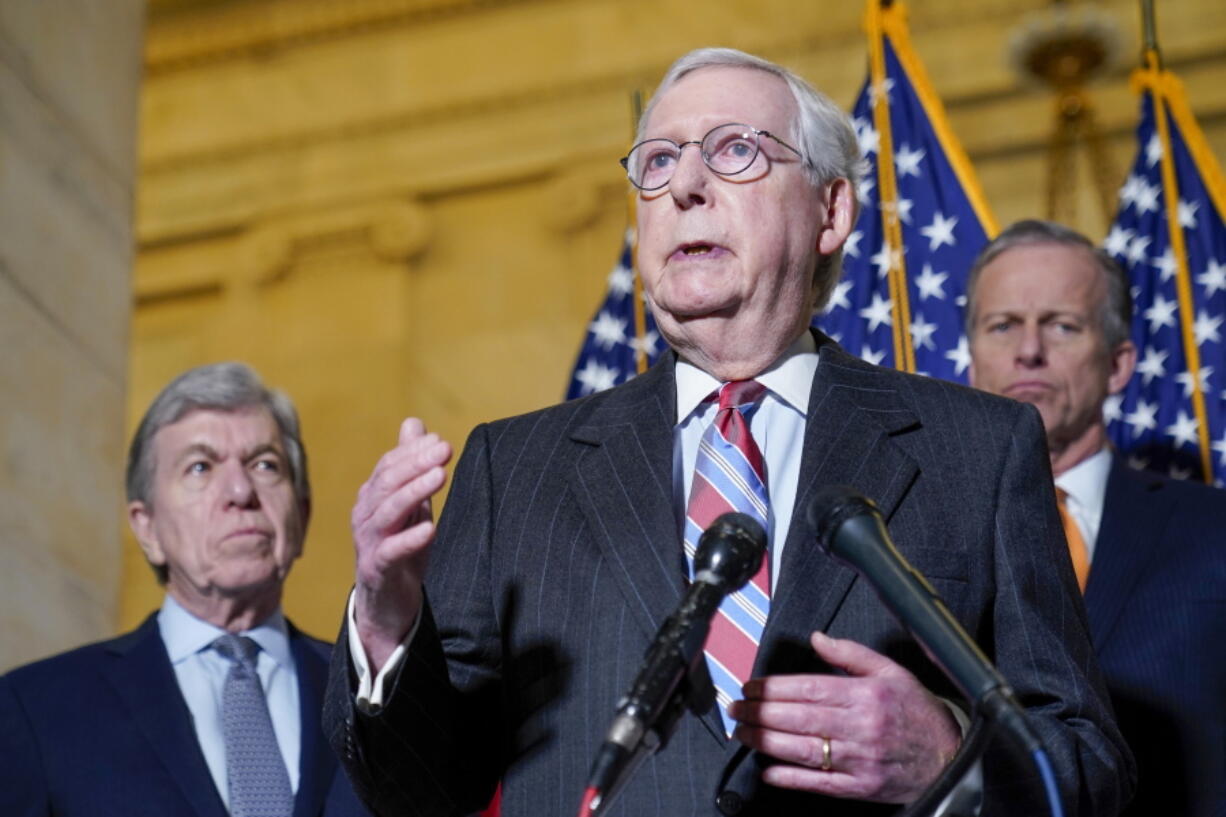 Senate Minority Leader Mitch McConnell of Ky., center, speaks to reporters on Capitol Hill in Washington, Tuesday, Feb. 8, 2022. Standing with McConnell is Sen. Roy Blunt, R-Mo., left, and Sen. John Thune, R-S.D., right.