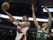 Portland Trail Blazers' Anfernee Simons, left, shoots against Milwaukee Bucks' Jordan Nwora (13) during the first half of an NBA basketball game Monday, Feb. 14, 2022, in Milwaukee.