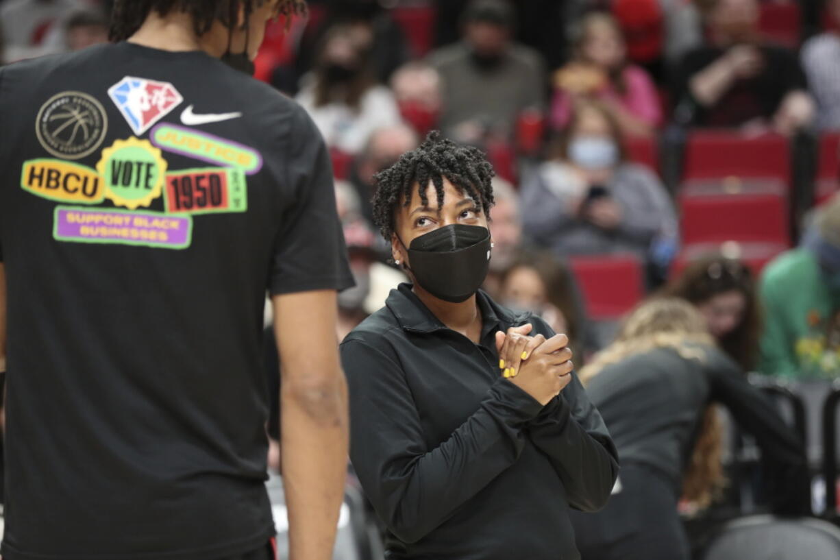 Portland Trail Blazers assistant coach Edniesha Curry talks with forward Greg Brown prior to an NBA basketball game against the New York Knicks in Portland, Ore., Saturday, Feb. 12, 2022. Curry is one of just six women currently working as assistants in the NBA and the first to work in that capacity for the Blazers.