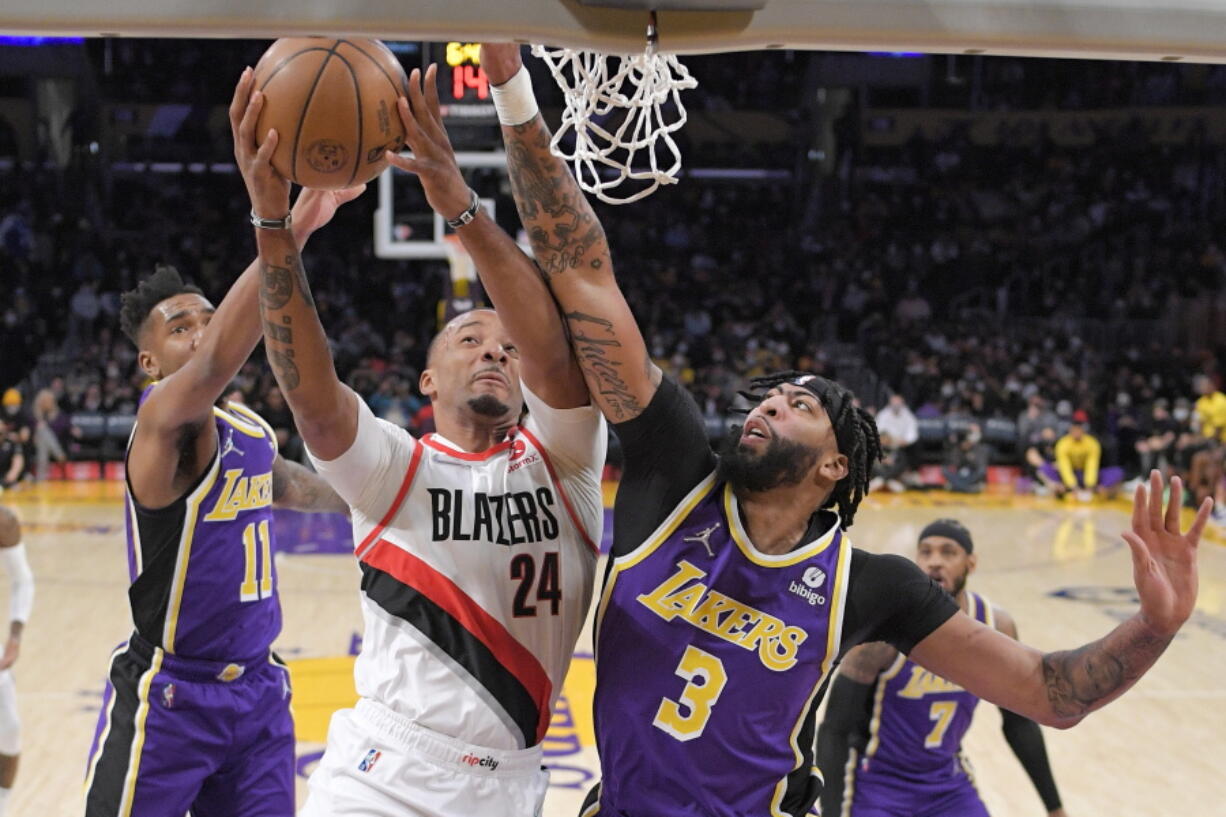 Portland Trail Blazers forward Norman Powell, center, shoots as Los Angeles Lakers guard Malik Monk, left, and forward Anthony Davis defend during the first half of an NBA basketball game Wednesday, Feb. 2, 2022, in Los Angeles. (AP Photo/Mark J.