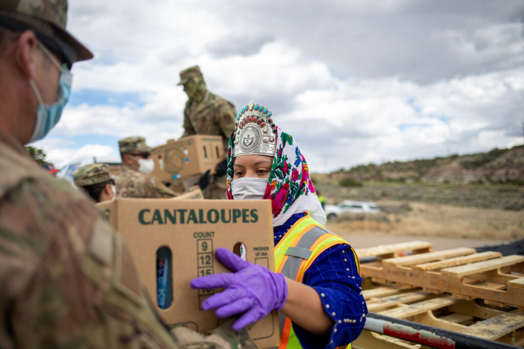 Miss Navajo Nation Shaandiin P. Parrish grabs a box filled with food and other supplies to distribute to Navajo families on May 27, 2020, in Counselor on the Navajo Nation Reservation, New Mexico.