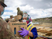 Miss Navajo Nation Shaandiin P. Parrish grabs a box filled with food and other supplies to distribute to Navajo families on May 27, 2020, in Counselor on the Navajo Nation Reservation, New Mexico.