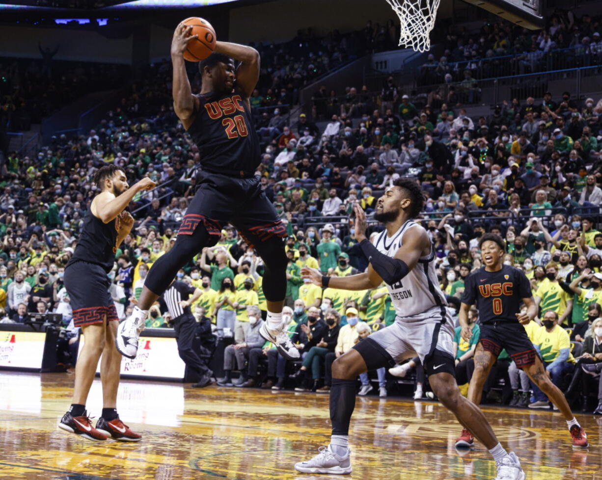 Southern California guard Ethan Anderson (20) pulls down a rebound against Oregon during the first half of an NCAA college basketball game in Eugene, Ore., Saturday, Feb. 26, 2022.