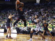 Southern California guard Ethan Anderson (20) pulls down a rebound against Oregon during the first half of an NCAA college basketball game in Eugene, Ore., Saturday, Feb. 26, 2022.