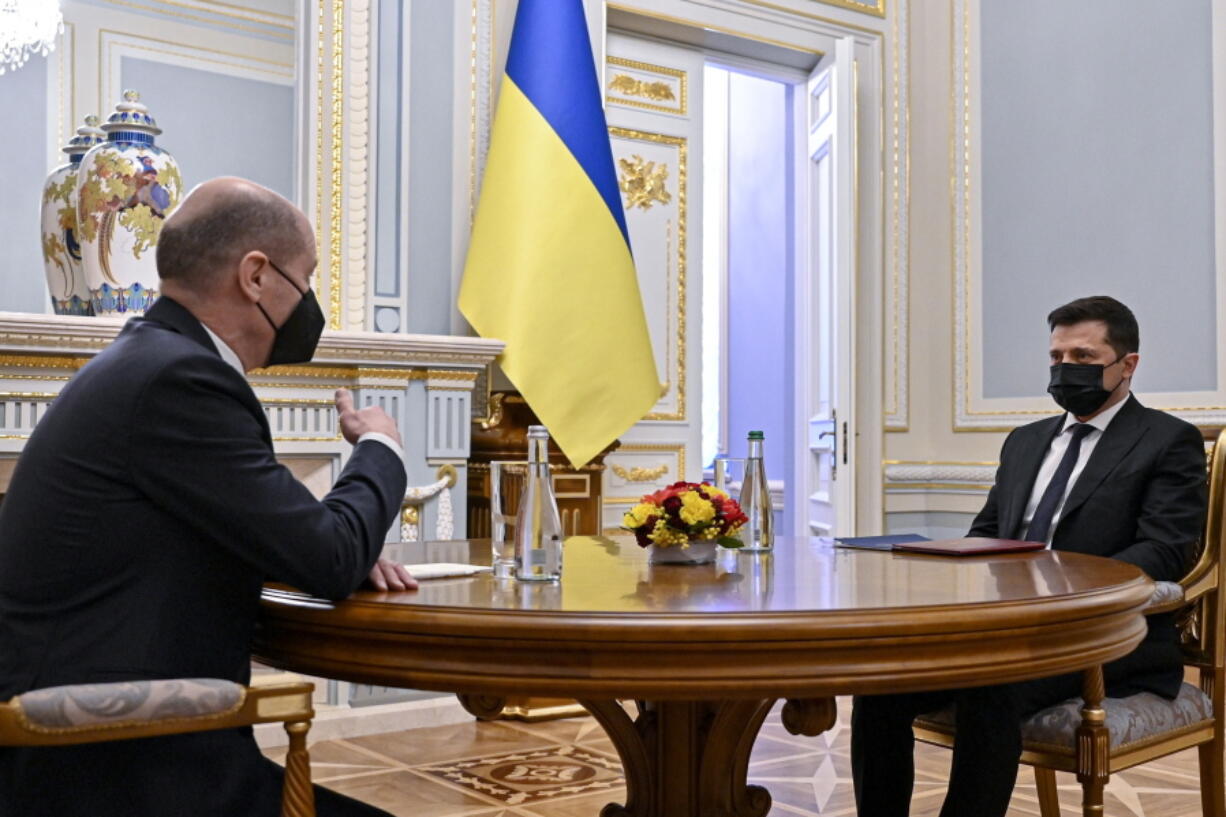 In this handout photo provided by the Ukrainian Presidential Press Office, Ukrainian President Volodymyr Zelenskyy, right, and German chancellor Olaf Scholz talk to each other during their meeting at The Mariinskyi Palace in Kyiv, Ukraine, Monday, Feb. 14, 2022. German Chancellor Olaf Scholz visited Ukraine as part of a flurry of Western diplomacy aimed at heading off a feared Russian invasion that some warn could be just days away.