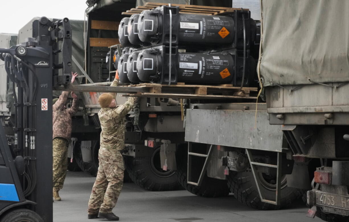 Ukrainian servicemen load Javelin anti-tank missiles, delivered as part of the United States of America's security assistance to Ukraine, into a military trucks at the Boryspil airport, outside Kyiv, Ukraine, Friday, Feb. 11, 2022. British Prime Minister Boris Johnson said Thursday the Ukraine crisis has grown into "the most dangerous moment" for Europe in decades, while his top diplomat held icy talks with her Moscow counterpart who said the Kremlin won't accept lectures from the West.